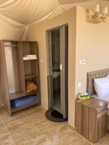 a room with a bedroom with a bed and a mirror at Lunara rum camp in Wadi Rum