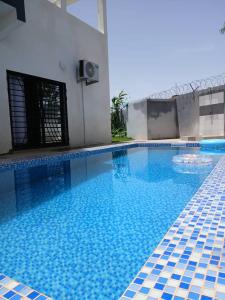 ein großer Pool mit blauen Fliesen in einem Gebäude in der Unterkunft Villa Standing Ngaparou in Ngaparou