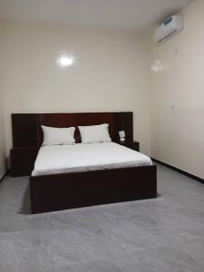 ein Schlafzimmer mit einem großen Bett mit einem hölzernen Kopfteil in der Unterkunft Villa Standing Ngaparou in Ngaparou