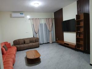 a living room with a couch and a flat screen tv at Villa Standing Ngaparou in Ngaparou
