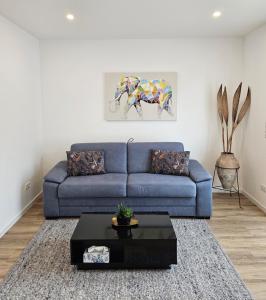 a living room with a blue couch and a table at FeWo Safari - zwischen Holstentor & Ostsee in Lübeck +12 photos