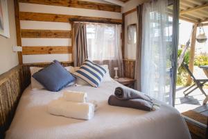 a bedroom with a bed with towels and a window at Carmela Suites Cabo Polonio in Cabo Polonio