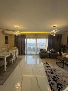 Una sala de estar con una mesa y un comedor. en شقة مطلة علي ممشي اهل مصر, en El Cairo