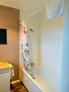 y baño con bañera y cortina de ducha. en Awatea Park Motel, en Palmerston North