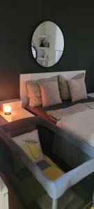 1 dormitorio con 1 cama con espejo en Apartman Riva Parking Garaža, en Kraljevo