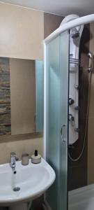 ein Badezimmer mit Waschbecken und Glasdusche in der Unterkunft Apartman Riva Parking Garaža in Kraljevo + 40 Fotos