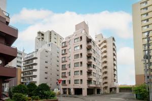 two tall white buildings in a city at Nakajima Park Mansion - Vacation STAY 20417 in Toyohira