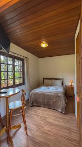 a bedroom with a bed and a wooden ceiling at Vila Dom Bosco in Campos do Jordão
