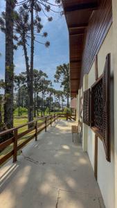 a porch of a building with a bench and trees at Vila Dom Bosco in Campos do Jordão