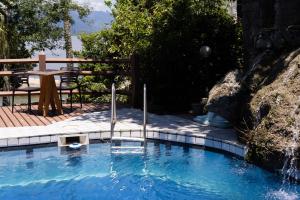 a swimming pool with a waterfall and a table at Hostel Jardim das Bruxas 410 in Florianópolis