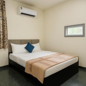 une chambre avec un lit avec un oreiller bleu dans l'établissement Shri Radhey Krishna Paying Guest House, à Mathura