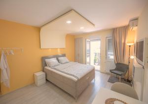 a bedroom with a bed and a chair in it at Amber Apartman in Banja Koviljača