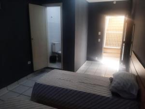 a bedroom with a bed and a door to a bathroom at Hotel Vitória Palace in Sao Paulo