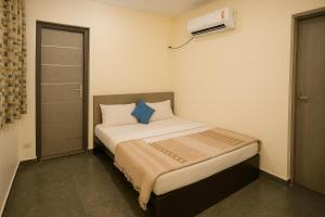 Cette petite chambre comprend un lit avec des oreillers bleus. dans l'établissement Shri Radhey Krishna Paying Guest House, à Mathura