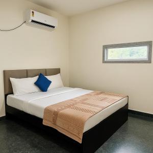 une chambre avec un lit avec un oreiller bleu dans l'établissement Shri Radhey Krishna Paying Guest House, à Mathura