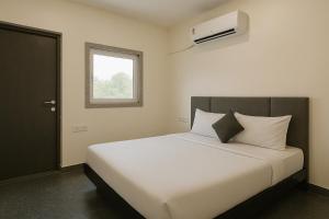 une chambre avec un grand lit blanc avec une fenêtre dans l'établissement Shri Radhey Krishna Paying Guest House, à Mathura