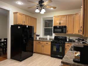 eine Küche mit einem schwarzen Kühlschrank und Holzschränken in der Unterkunft Cozy home in Soulard in Saint Louis