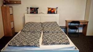 a bed with a blanket on it in a room at Ezee Rider Apartmanok in Sárvár