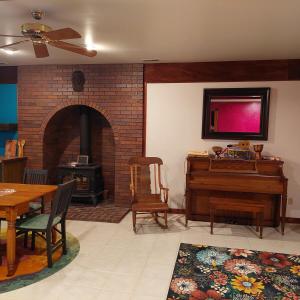 a living room with a table and a piano at Cirque Stay in Lawrence