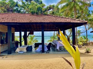 un gazebo sulla spiaggia con tavoli e sedie di kuda Bay Surf Hostel ad Arugam