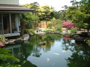 ein Teich vor einem Haus mit Drachen in der Unterkunft Kohan in Niigata