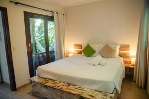 a bedroom with a large white bed and a window at Recanto da Mata Pipa in Pipa +100 photos