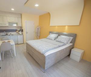 een slaapkamer met een groot bed en een keuken bij Amber Apartman in Banja Koviljača