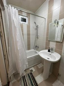 a bathroom with a sink and a toilet and a bath tub at Aviator Apartment in Bina