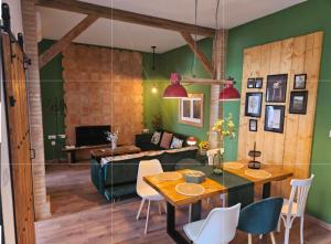 a living room with green walls and a table and chairs at Loft Home Torremirador a 40min Sevilla y Doñana in Villalba del Alcor
