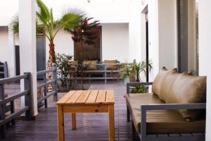 a porch with a couch and a table and palm trees at Dar naima in Al Ghar