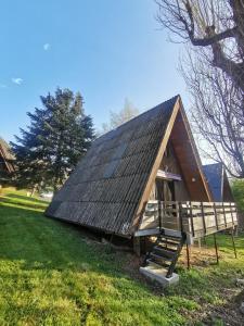 Una cabaña con techo abuhardillado en un campo verde en CHALET 4 Le Cerf, en Cierp