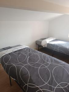 two beds sitting in a room with at La fin de journée-T3-Wifi-parking in Saint-Yrieix-sur-Charente