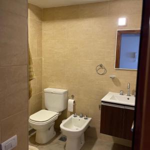 a bathroom with a toilet and a sink at Aire de Mar II - Alojamientos Necochea in Necochea