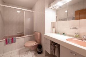 a white bathroom with a toilet and a sink at Gasthof zur alten Post in Büren an der Aare +2 photos