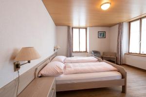 a bedroom with a large bed in a room with windows at Gasthof zur alten Post in Büren an der Aare