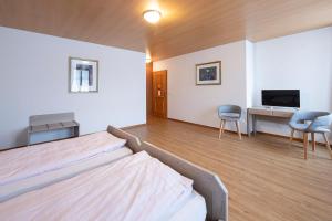 a bedroom with a bed and a desk and a tv at Gasthof zur alten Post in Büren an der Aare