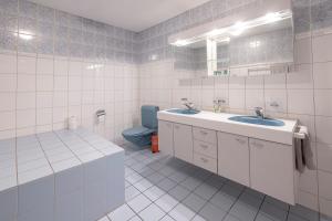 a bathroom with two sinks and a blue toilet at Gasthof zur alten Post in Büren an der Aare