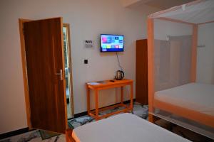 Firas Village في واتامو: غرفة نوم بسرير وتلفزيون على الحائط +67 صورة