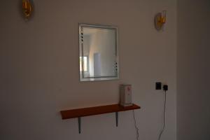 Firas Village في واتامو: مرآة على جدار مع رف خشبي
