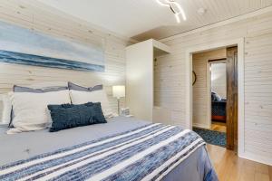 a bedroom with a bed with a blue and white comforter at Walk to Marina and Beach Charming Home in Hardin in Aurora
