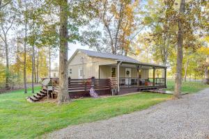 a cabin in the woods with a porch and trees at Walk to Marina and Beach Charming Home in Hardin in Aurora