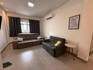 a living room with a couch and a table at Apê pé na areia in Santos