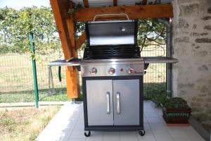 a grill with a stove top on a patio at GITE MONTGOLFIÈRE 6 PERSONNES in Châtellerault