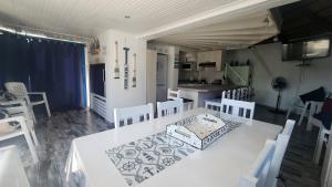 Un comedor con una mesa y sillas blancas. en Pamperlang, en Dwarskersbos