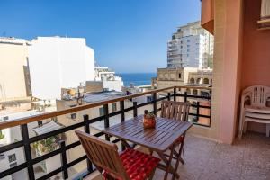 a table and chairs on a balcony with a view of the ocean at Spacious 3-Bedroom Apartment with Balconies-Central Sliema in Sliema