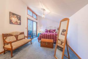 a bedroom with a bed and a mirror and a chair at Charming 3 bed 2 bath home near dunes, beach and trails in South Haven