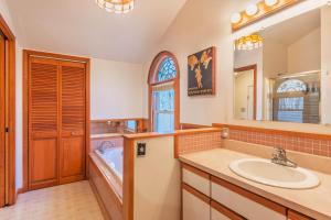 a bathroom with a sink and a tub and a mirror at Charming 3 bed 2 bath home near dunes, beach and trails in South Haven +21 photos