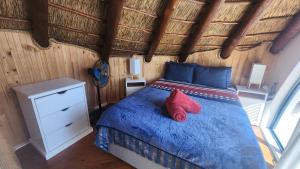 Un dormitorio con una cama con zapatos rojos. en Pamperlang, en Dwarskersbos 18 fotos más