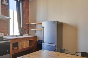 a kitchen with a stainless steel refrigerator and a table at Convenient Couples Retreat in Dtwn Marshall! in Marshall