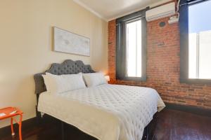 a bedroom with a bed and a brick wall at Convenient Couples Retreat in Dtwn Marshall! in Marshall